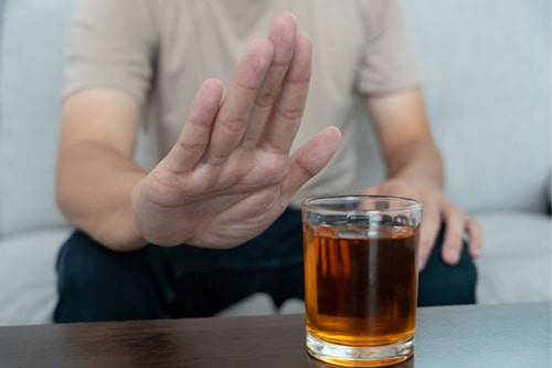 Man holding up hand to alcohol