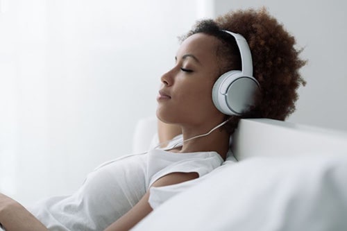 Woman listening to music with white headphones